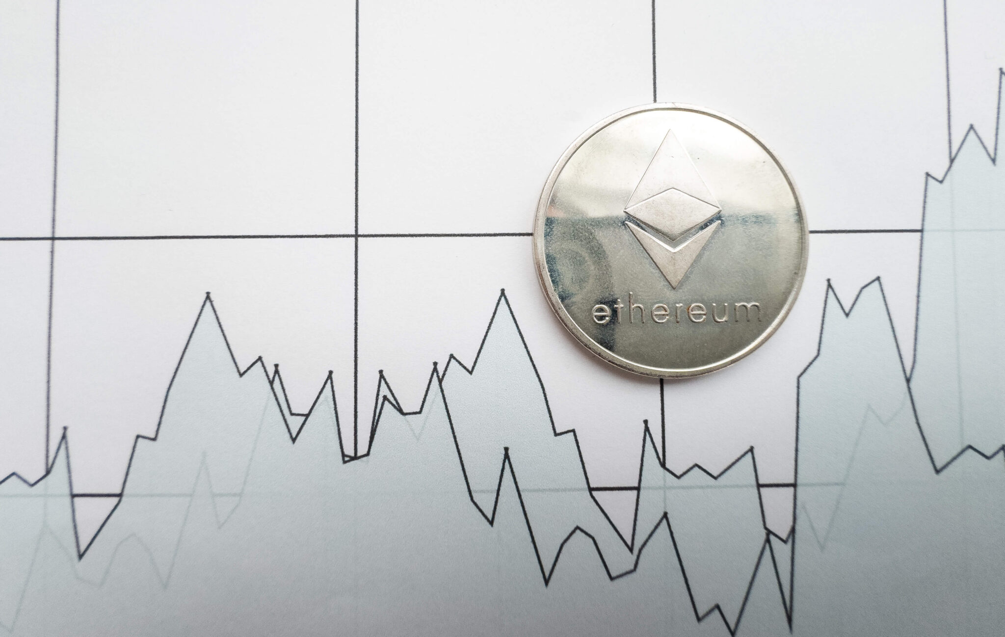 white financial line chart with silver ethereum coin